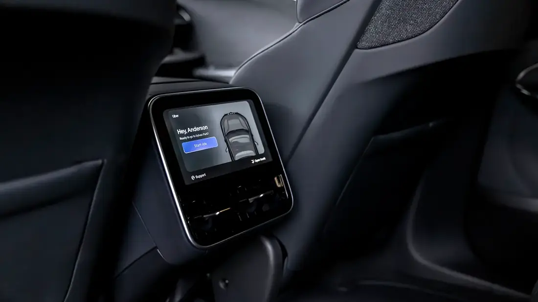A rear-seat touchscreen in the Lucid Gravity robotaxi showing an Uber greeting, a Start ride button, Open trunk and Support